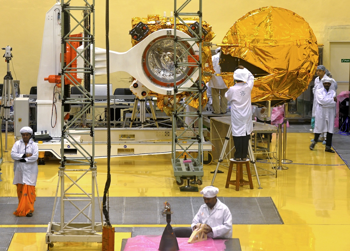 Scientists at India's space agency work on a satellite